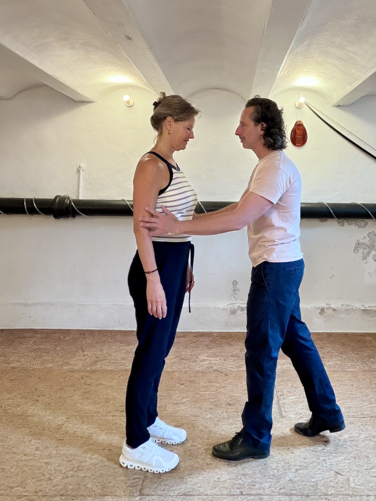 Damian Rosenthal adjusting Esther Jacobs’ posture during tango coaching