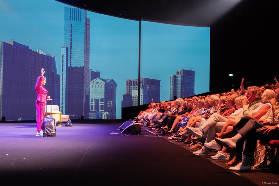 Esther Jacobs vertelt een verhaal aan een betrokken theaterpubliek