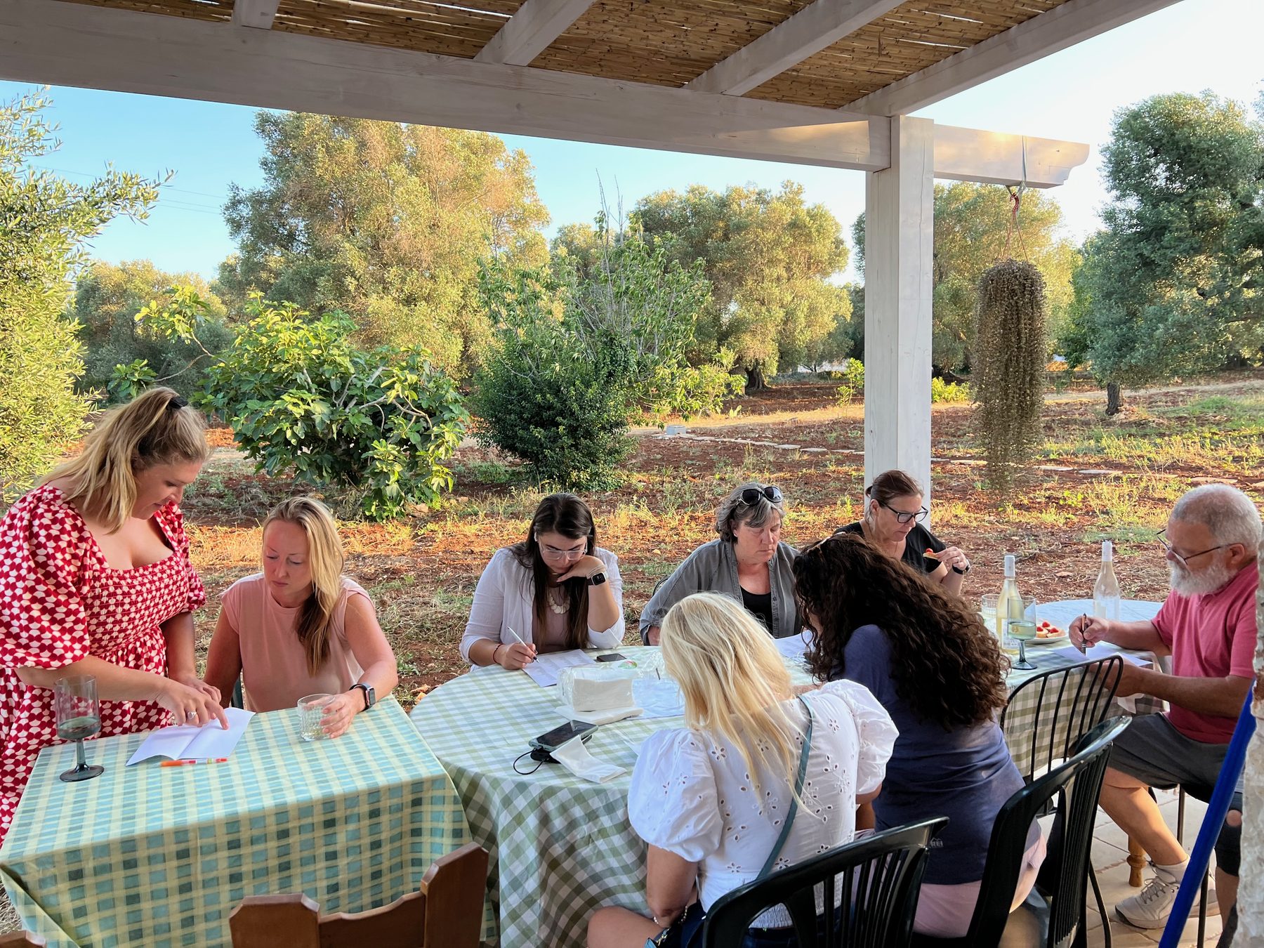 Deelnemers werken samen tijdens een schrijfworkshop op het terras.