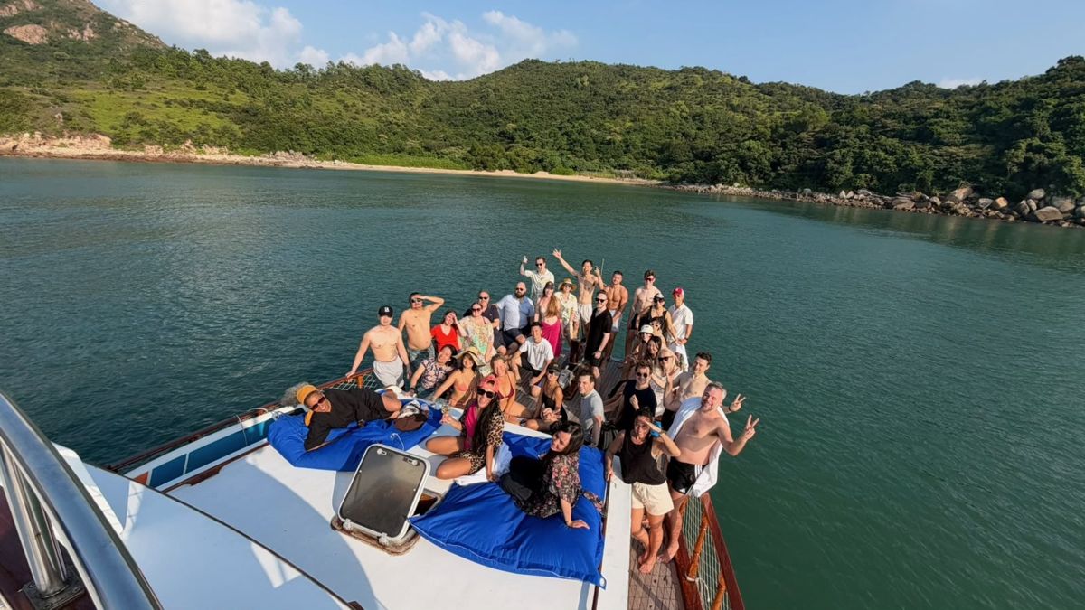 Dynamite Circle-groep op een junkboat bij een groene baai in Hongkong Dynamite Circle-groep op een junkboat bij een groene baai in Hongkong
